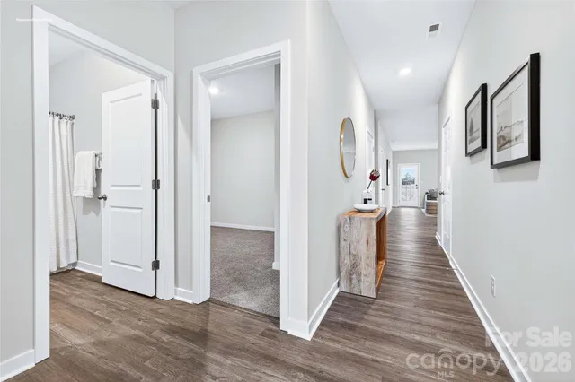 a view of a hallway with wooden floor and staircase