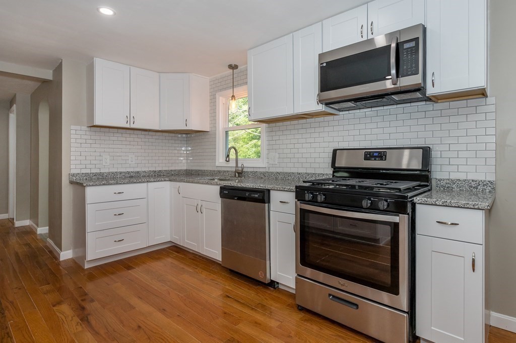 45 Shore Road Ashland, MA 01721 - Photo 4 of 21 a kitchen with white cabinets and stainless steel appliances