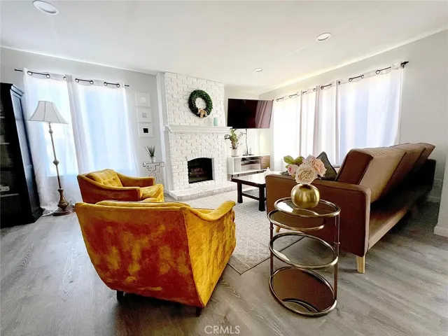 a living room with furniture a fireplace and a flat screen tv