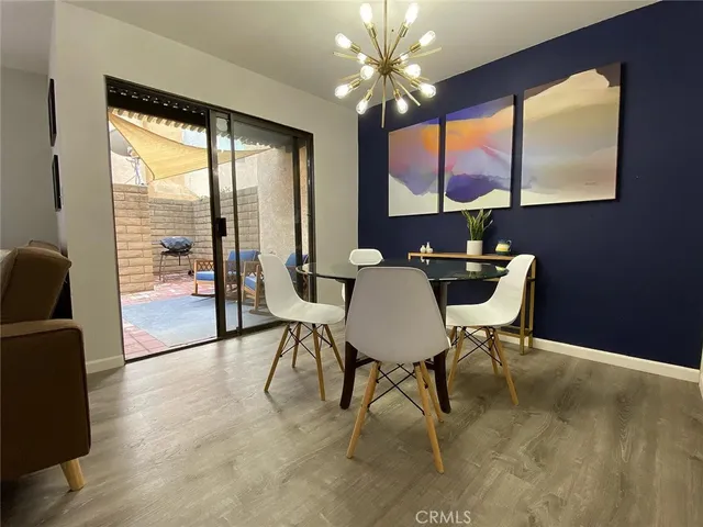 a dining room with furniture a chandelier and wooden floor