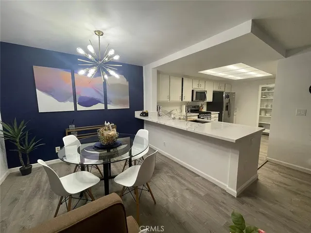 a large white kitchen with wooden floor