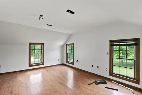 wooden floor in an empty room with a window