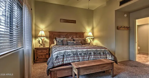 a bedroom with a bed a lamp and a window