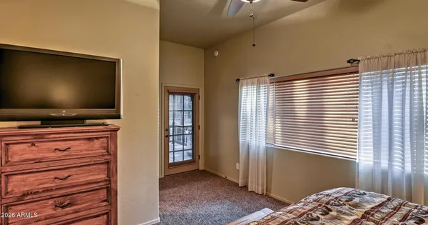 a bedroom with window and flat screen tv