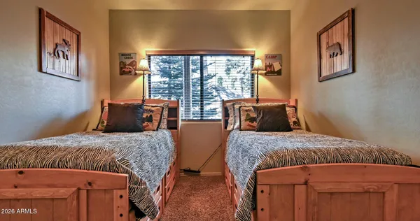 a bedroom with two beds and wooden floor