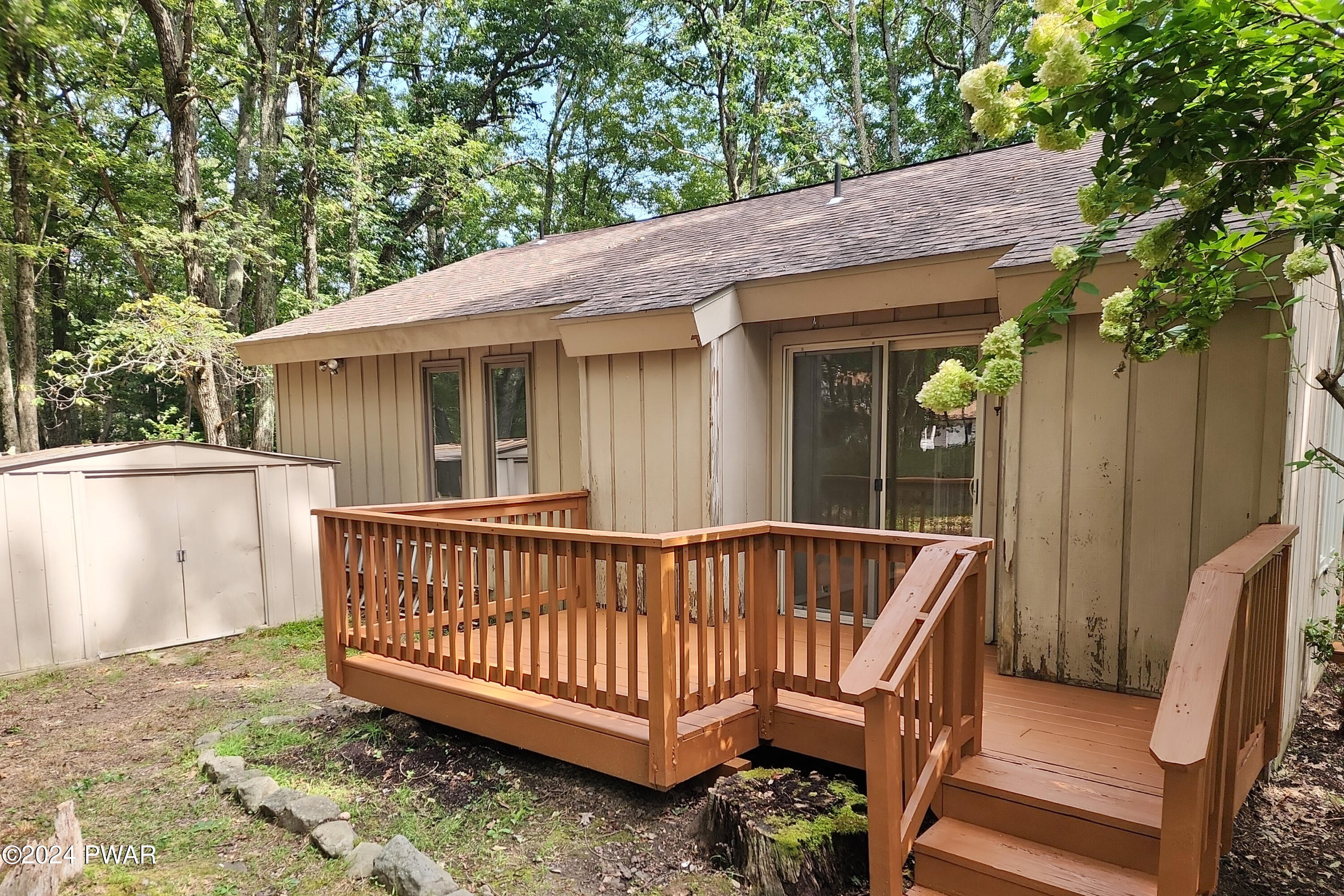 107 Rodeo Lane Hawley, PA 18428 - Photo 26 of 29 a view of a house with a wooden deck and furniture