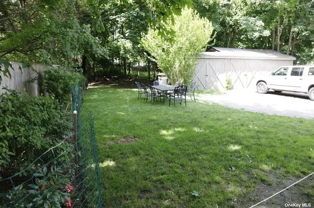 a view of backyard with a table and chairs and potted plants