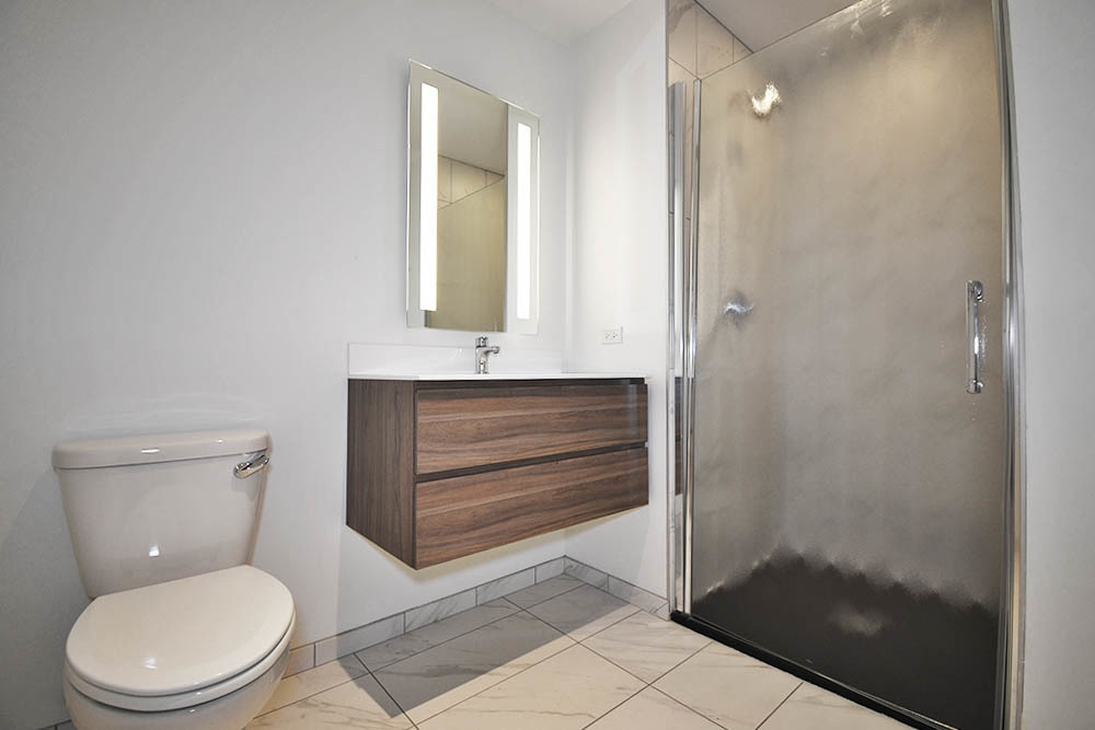 1515 North Fremont Street, Unit 212 Chicago, IL 60642 - Photo 5 of 8 a bathroom with a toilet a sink and shower
