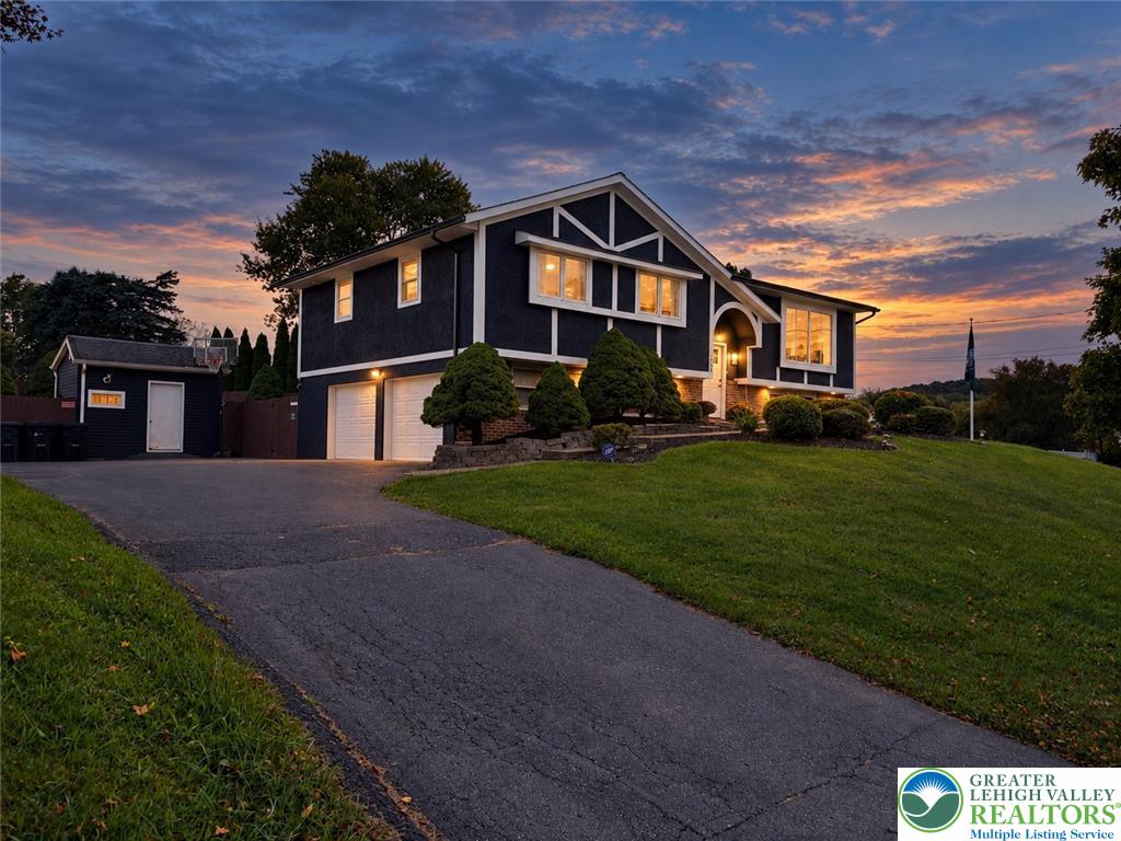 2930 Oakland Road Bethlehem, PA 18017 - Photo 6 of 55 A paved driveway leads to a multi-level home featuring dark siding and white trim.