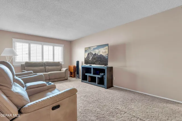 a living room with furniture and a dresser