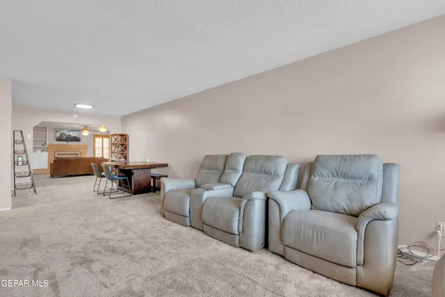 a open kitchen with stainless steel appliances granite countertop a stove a sink a dining table and chairs with white cabinets