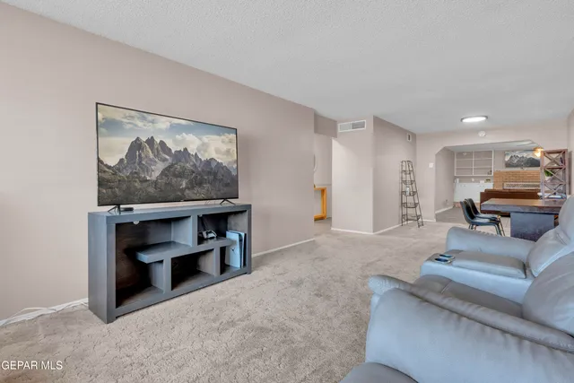 a open kitchen with stainless steel appliances granite countertop a stove a refrigerator a dining table and chairs with wooden floor