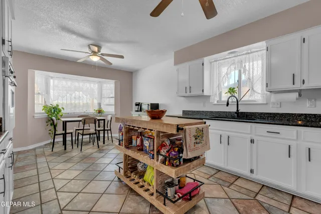 a kitchen with stainless steel appliances granite countertop a refrigerator a stove a sink and a window