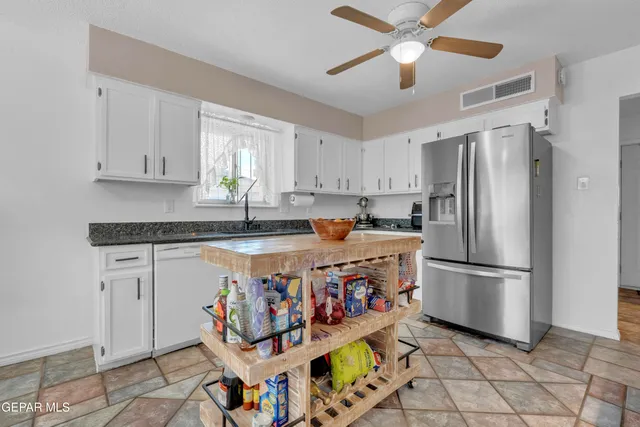 a kitchen filled with stainless steel appliances granite countertop a sink and a refrigerator