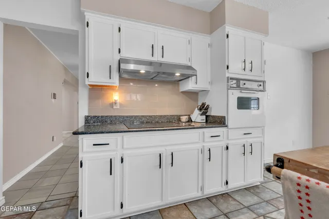 a kitchen with stainless steel appliances granite countertop a refrigerator a stove a sink and dishwasher