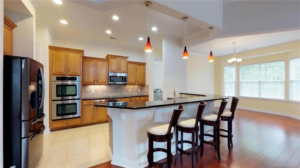 1369 Secret Path Drive Fort Mill, SC 29708 - Photo 8 of 22 a kitchen with stainless steel appliances granite countertop a kitchen island a table and chairs in it