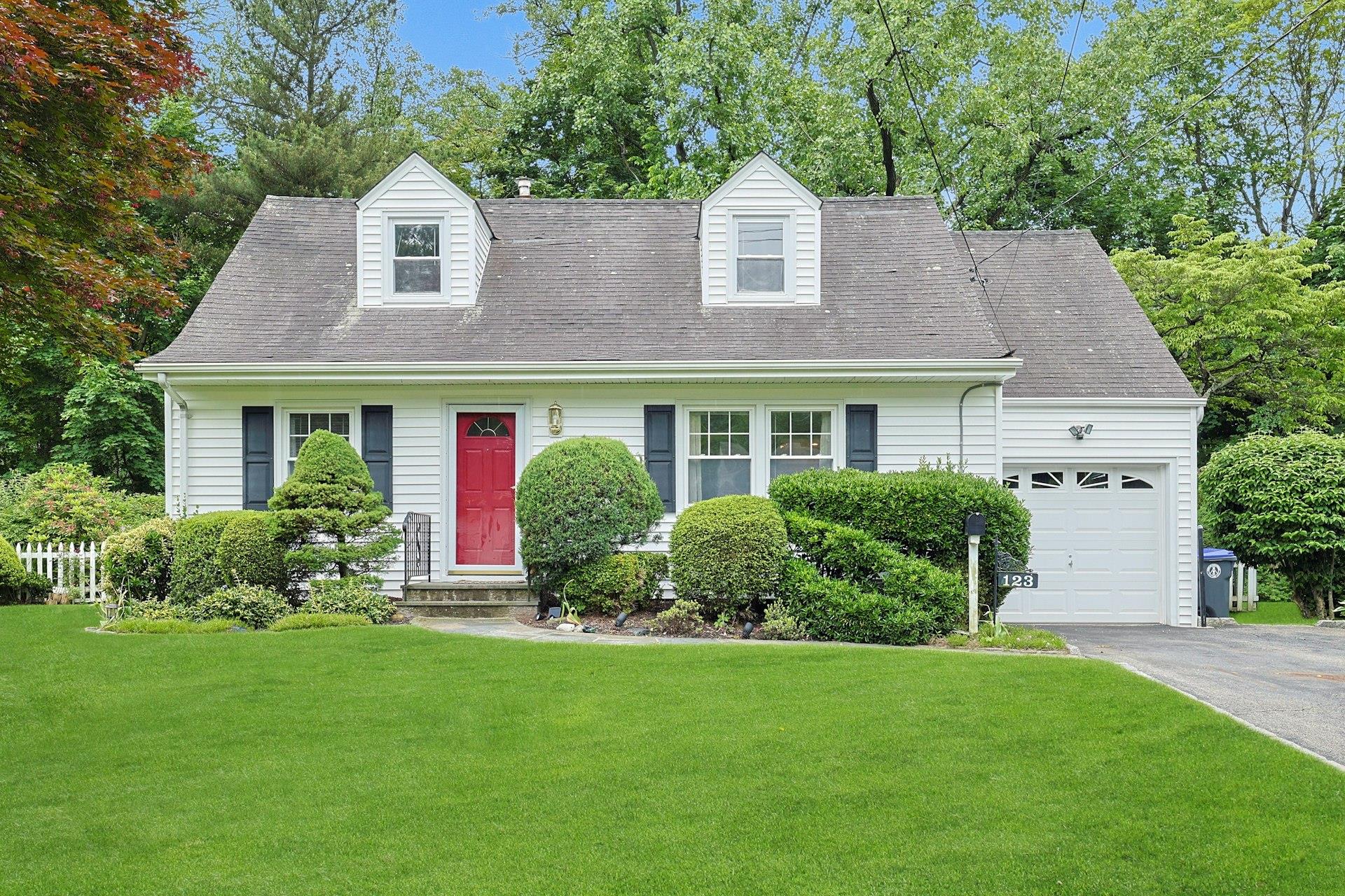 a front view of a house with a yard and trees