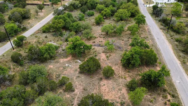 an aerial view of residential house with outdoor space and trees all around