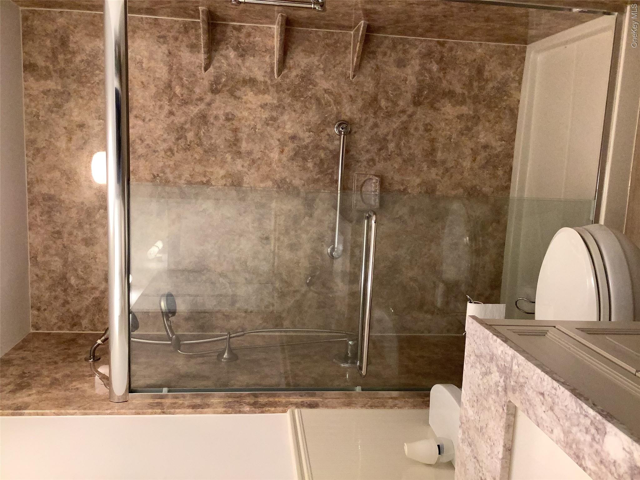 406 Woodbridge Drive, Unit B Ridge, NY 11961 - Photo 4 of 5 a bathroom with a granite countertop shower toilet and sink