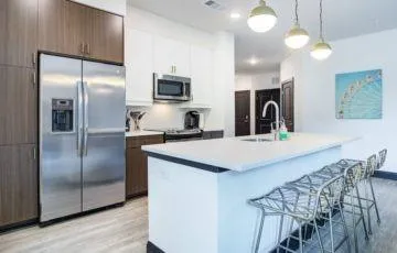 a kitchen with stainless steel appliances kitchen island a refrigerator sink and microwave