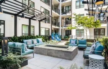 a view of a patio with couches table and chairs and potted plants
