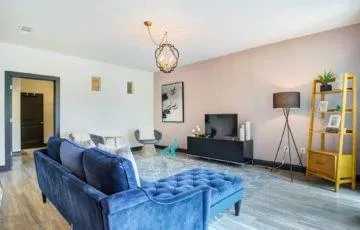 a living room with furniture a flat screen tv and a window