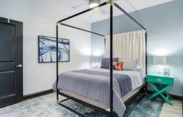 a bedroom with a bed a lamp and paintings on the wall