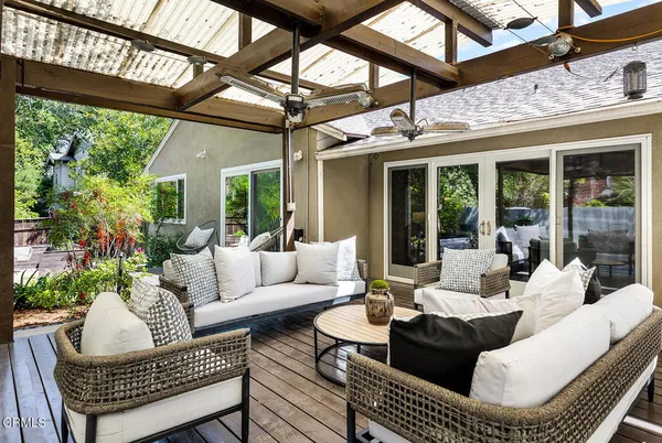a living room with patio furniture and a potted plant