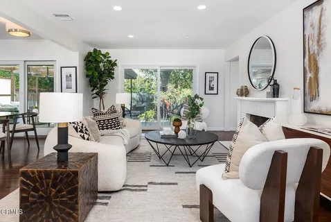 a living room with fireplace furniture and a large window