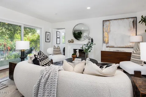 a living room with furniture a large window and a fireplace