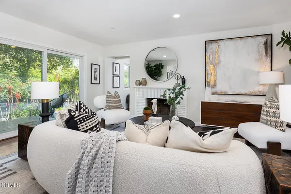 a living room with furniture a large window and a fireplace