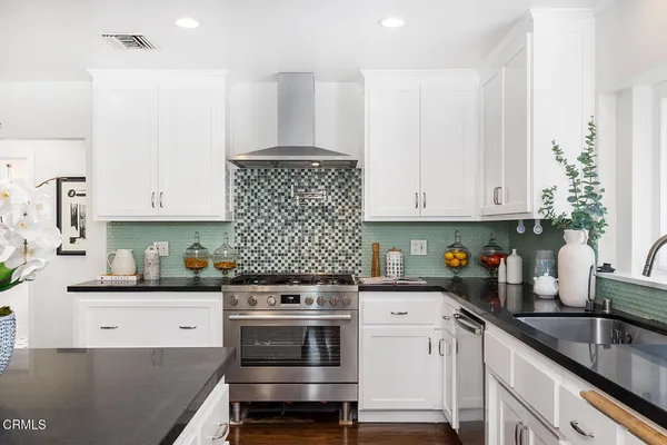 a kitchen with granite countertop a stove sink and cabinets