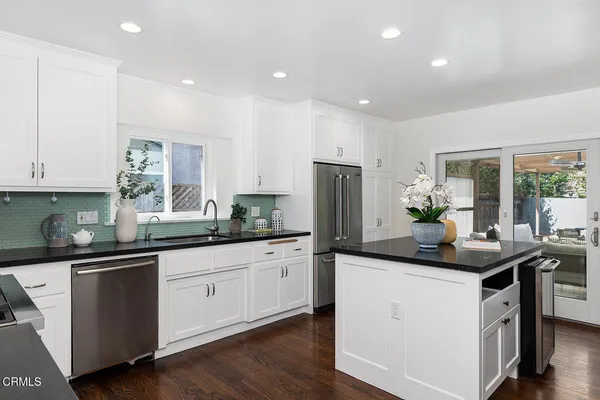 a kitchen with stainless steel appliances granite countertop a sink and cabinets