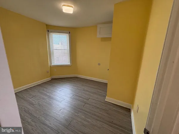 a view of a room with wooden floor and brick walls