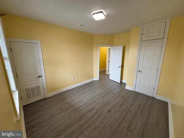 an empty room with wooden floor and entrance