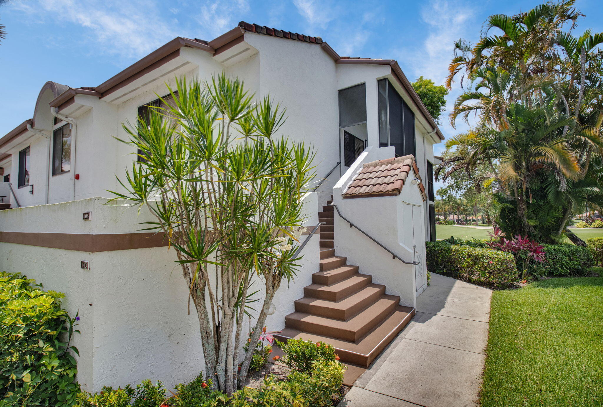 7380 Clunie Place, Unit 13006 Delray Beach, FL 33446 - Photo 31 of 67 a view of a white house with a yard and potted plants