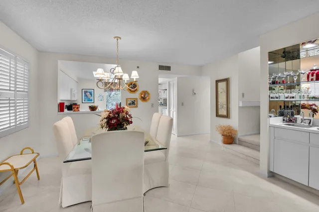 a living room with furniture a chandelier and a dining table