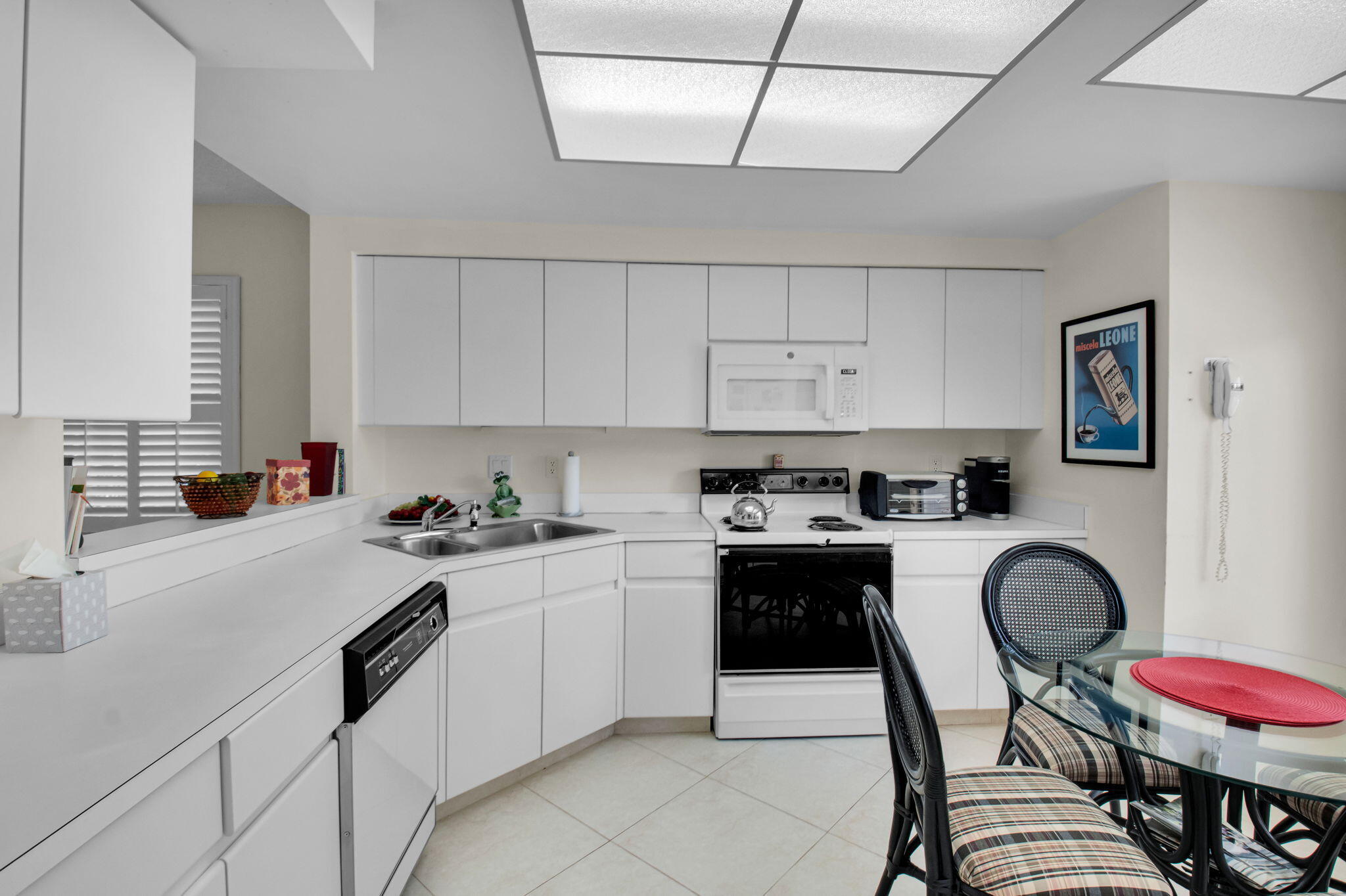 7380 Clunie Place, Unit 13006 Delray Beach, FL 33446 - Photo 9 of 67 a kitchen with a sink a stove and white cabinets