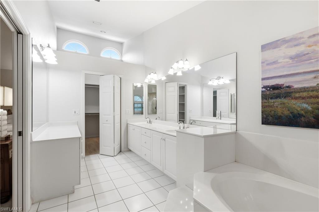 203 Via Perignon, Unit 24 Naples, FL 34119 - Photo 19 of 42 Primary Bath w/ dual vanities leading to Walk-in Closet