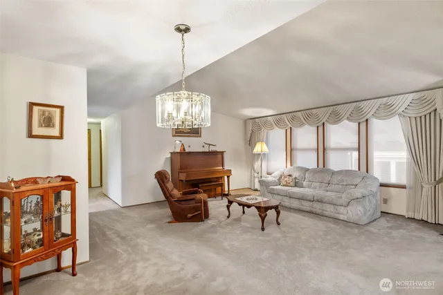 a living room with furniture a dining table and a chandelier