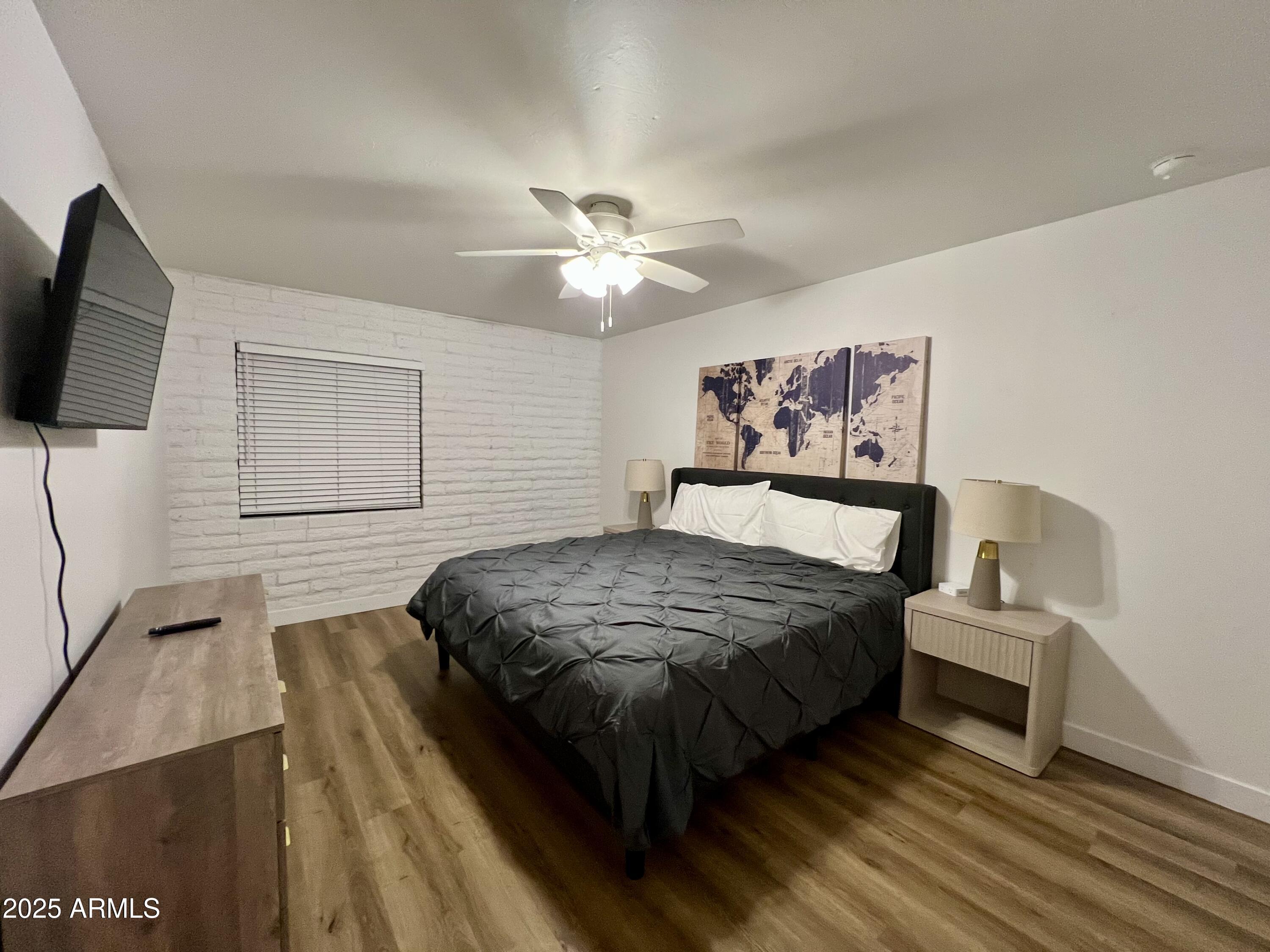 3046 North 32nd Street, Unit 333 Phoenix, AZ 85018 - Photo 8 of 16 a bedroom with a bed and a flat screen tv