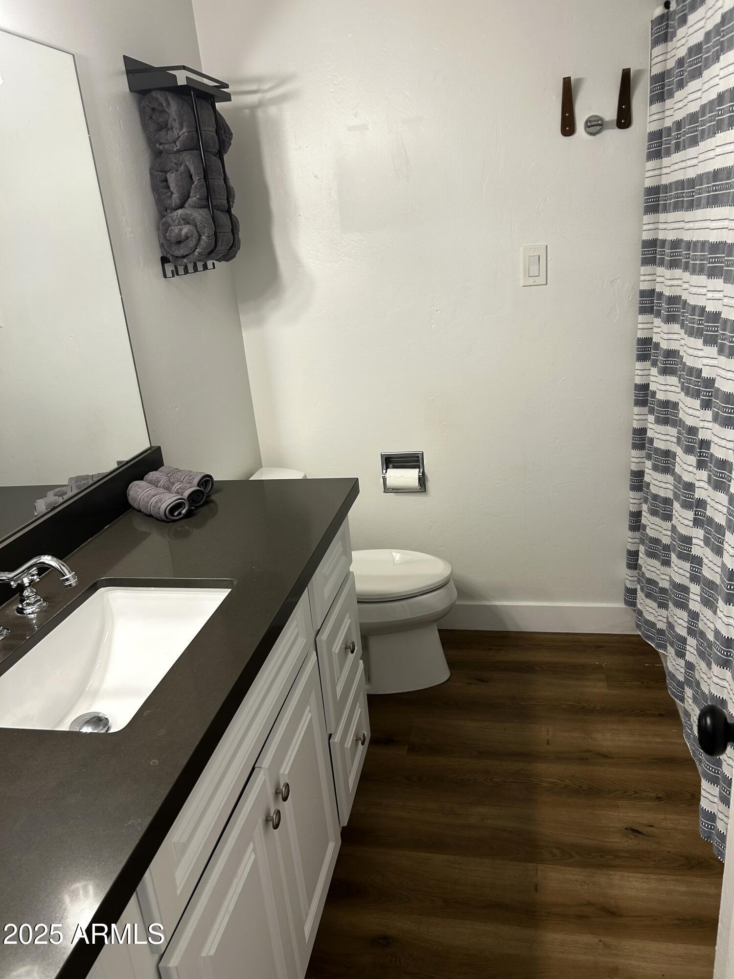 3046 North 32nd Street, Unit 333 Phoenix, AZ 85018 - Photo 9 of 16 a bathroom with a granite countertop sink toilet and mirror