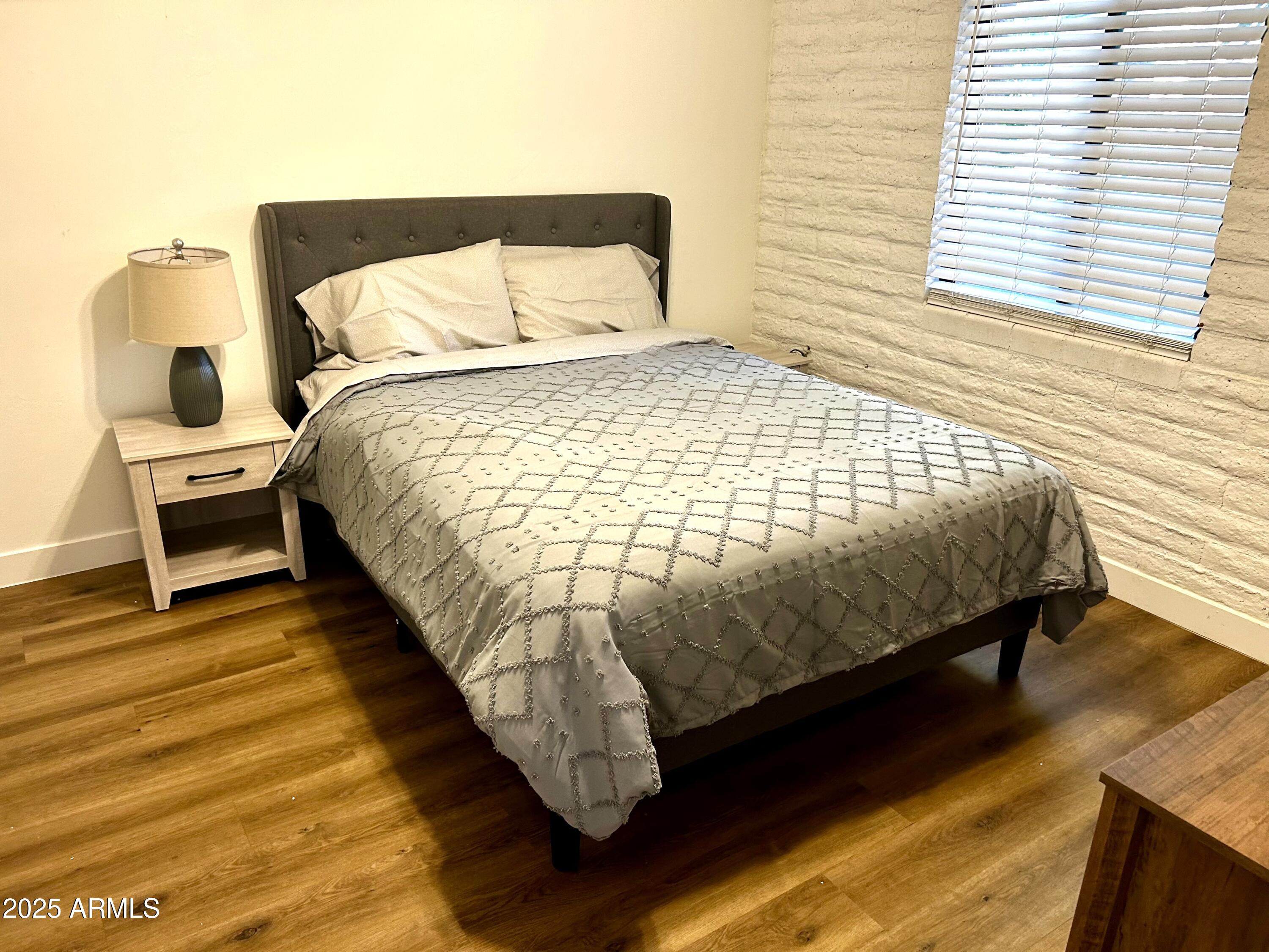 3046 North 32nd Street, Unit 333 Phoenix, AZ 85018 - Photo 10 of 16 a bed sitting in a bedroom next to a window