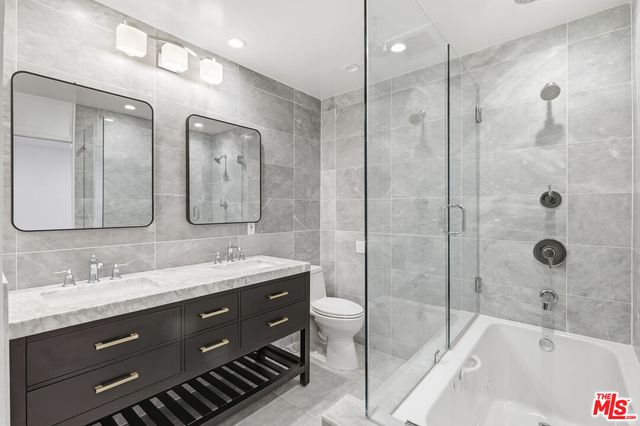 a bathroom with a double vanity sink mirror double and bathtub