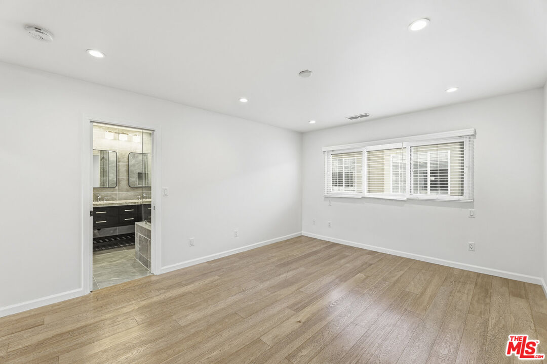 2442 South Coast Highway, Unit 4 Laguna Beach, CA 92651 - Photo 15 of 22 a view of empty room with wooden floor and fan