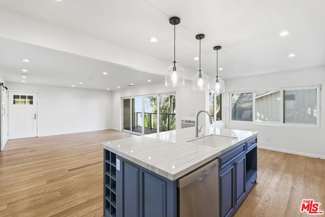 a kitchen with a sink and wooden floor