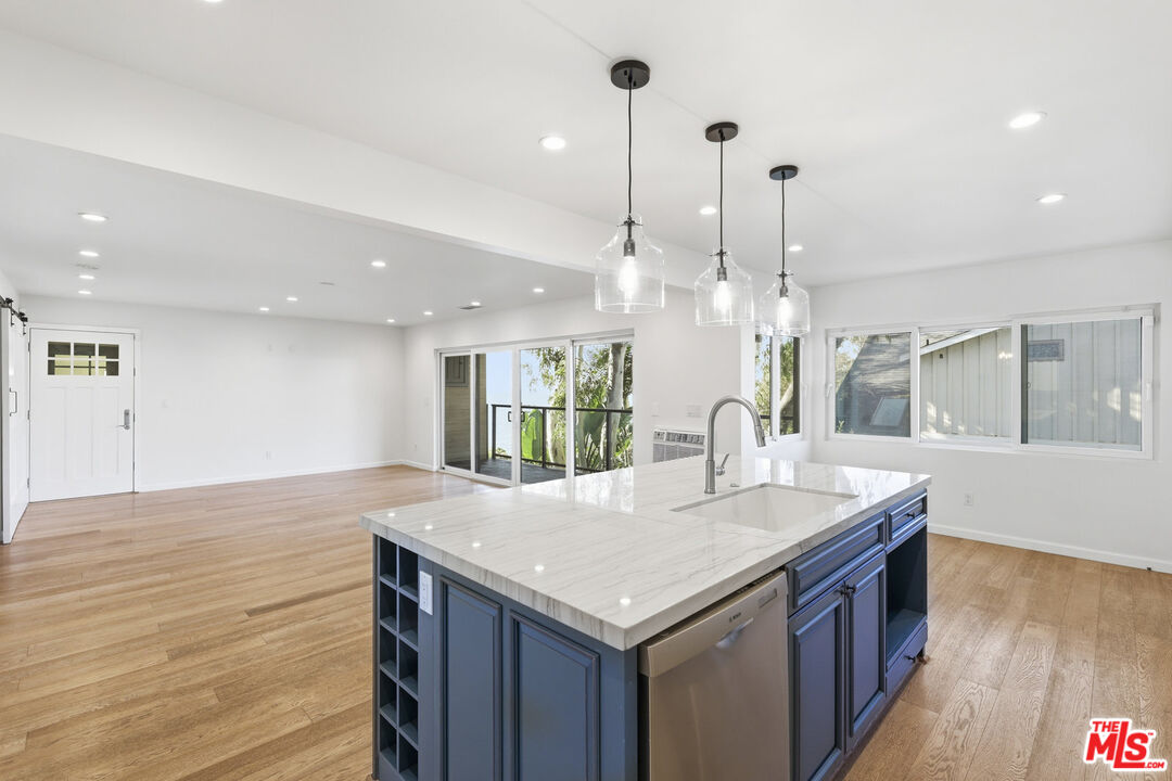 2442 South Coast Highway, Unit 4 Laguna Beach, CA 92651 - Photo 2 of 22 a kitchen with a sink and wooden floor