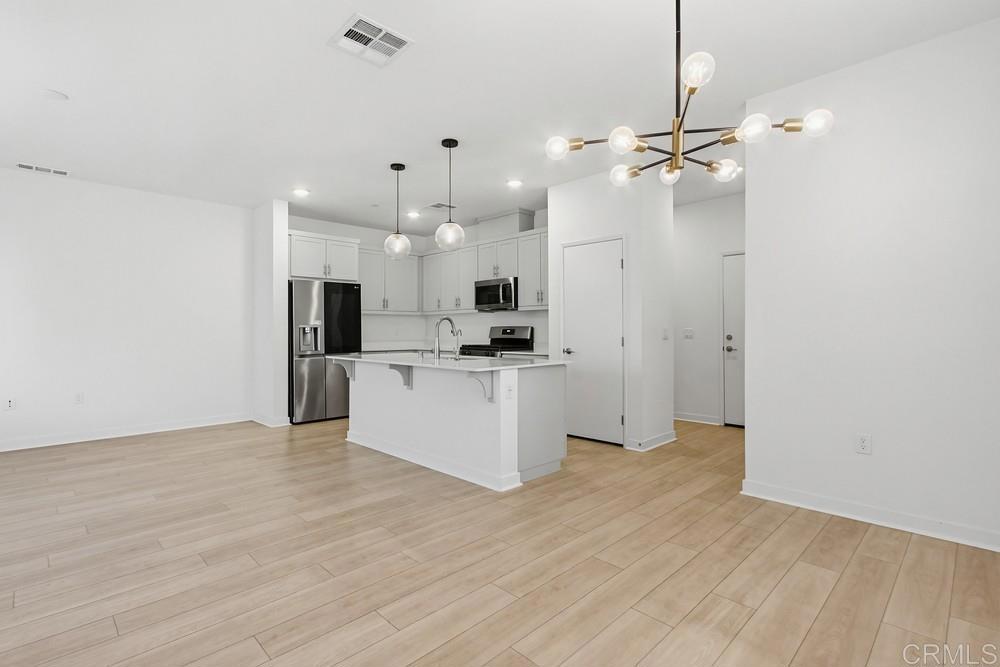 35131 Rangpur Lane Fallbrook, CA 92028 - Photo 21 of 61 a view of kitchen with stainless steel appliances kitchen island hardwood floor and a ceiling fan