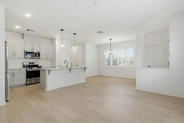 a kitchen with stainless steel appliances kitchen island a white cabinets and refrigerator