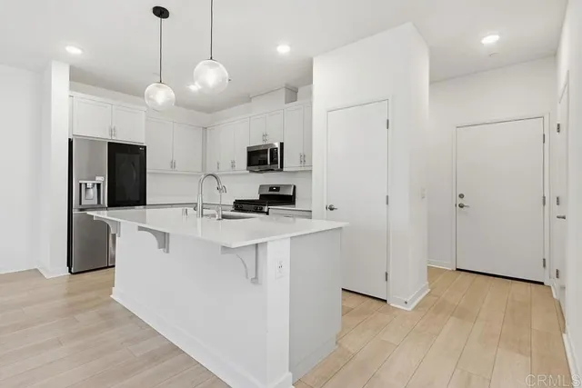 a view of a kitchen with a sink a window and stainless steel appliances